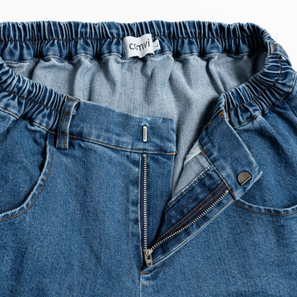 Close-up of adaptive jeans with hook-and-loop fly and discreet pull-up loops integrated as belt loops.

