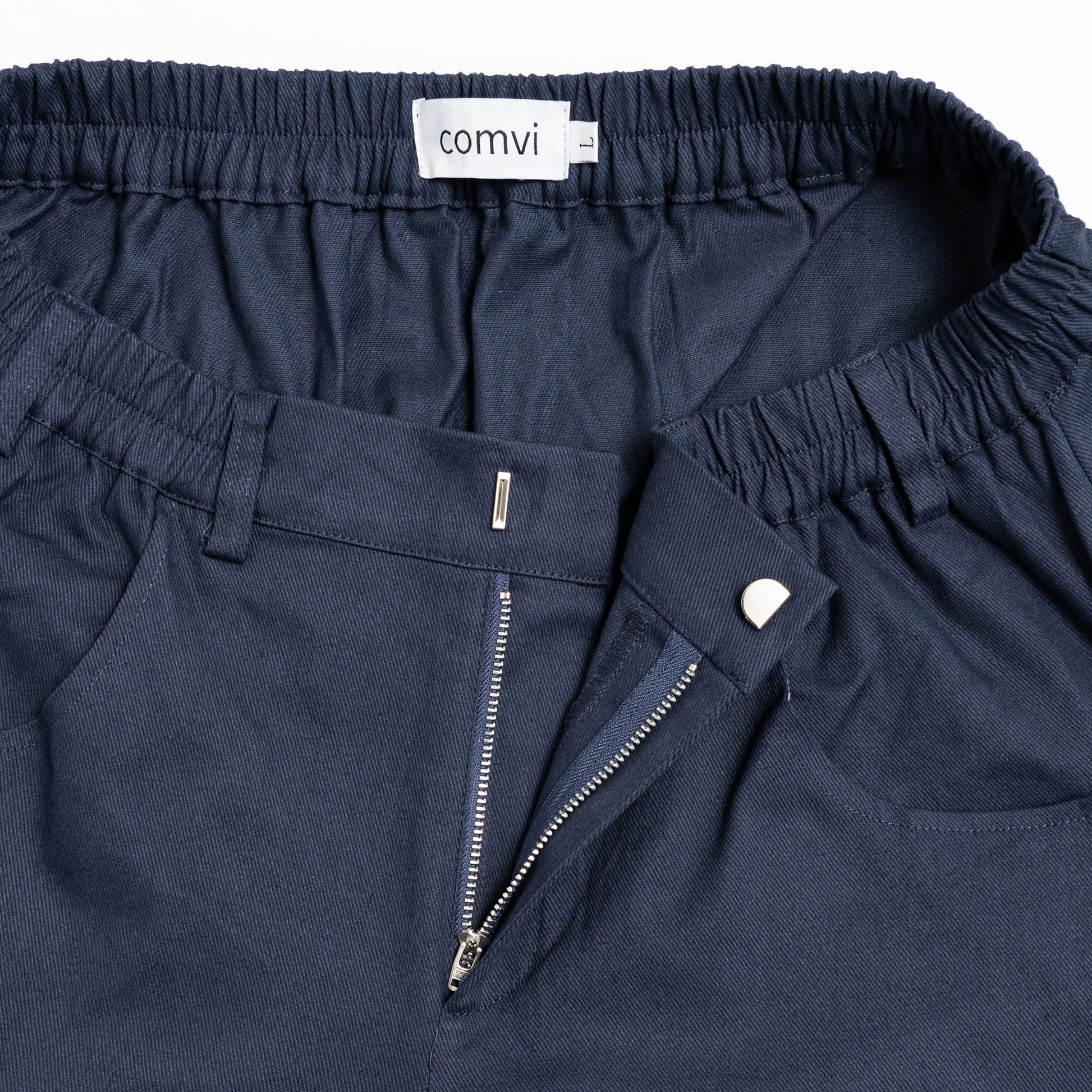 “Close-up of pull-up loops disguised as belt loops for easier dressing and adaptive hook-and-loop fly closure.”